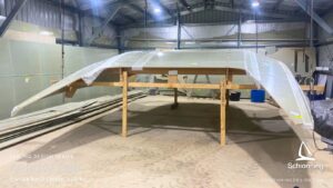 Schionning Designs - Arrow 1360 - 1st 6Months Build Progress - Arrow 1360 Catamaran owner build review located in Perth, Western Australia Demonstrates Schionning Designs detailed multihull kit construction system Shows how experienced owner-builders achieve precise alignment and excellent structural consistency Professional-level results using composite kit construction Six month build progress with hull panels fitted, glassed, and ready for fairing Cabin top constructed first and hoisted into shed roof due to space constraints Main crossing bulkheads joined and reinforcements completed Bulkheads stacked in installation order for efficient workflow MDF build jigs supplied with kit, quick to assemble and accurate Hull jig built in two days with frames aligned to DuFlex panels Forebeam and daggerboards constructed alongside main build Goal to complete bridge deck and hulls by May Bulkhead and bridge deck installation planned for June Exciting and rewarding owner build journey