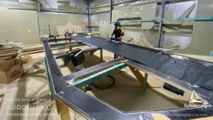 Schionning Designs - Arrow 1360 - 1st 6Months Build Progress - Arrow 1360 Catamaran owner build review located in Perth, Western Australia Demonstrates Schionning Designs detailed multihull kit construction system Shows how experienced owner-builders achieve precise alignment and excellent structural consistency Professional-level results using composite kit construction Six month build progress with hull panels fitted, glassed, and ready for fairing Cabin top constructed first and hoisted into shed roof due to space constraints Main crossing bulkheads joined and reinforcements completed Bulkheads stacked in installation order for efficient workflow MDF build jigs supplied with kit, quick to assemble and accurate Hull jig built in two days with frames aligned to DuFlex panels Forebeam and daggerboards constructed alongside main build Goal to complete bridge deck and hulls by May Bulkhead and bridge deck installation planned for June Exciting and rewarding owner build journey